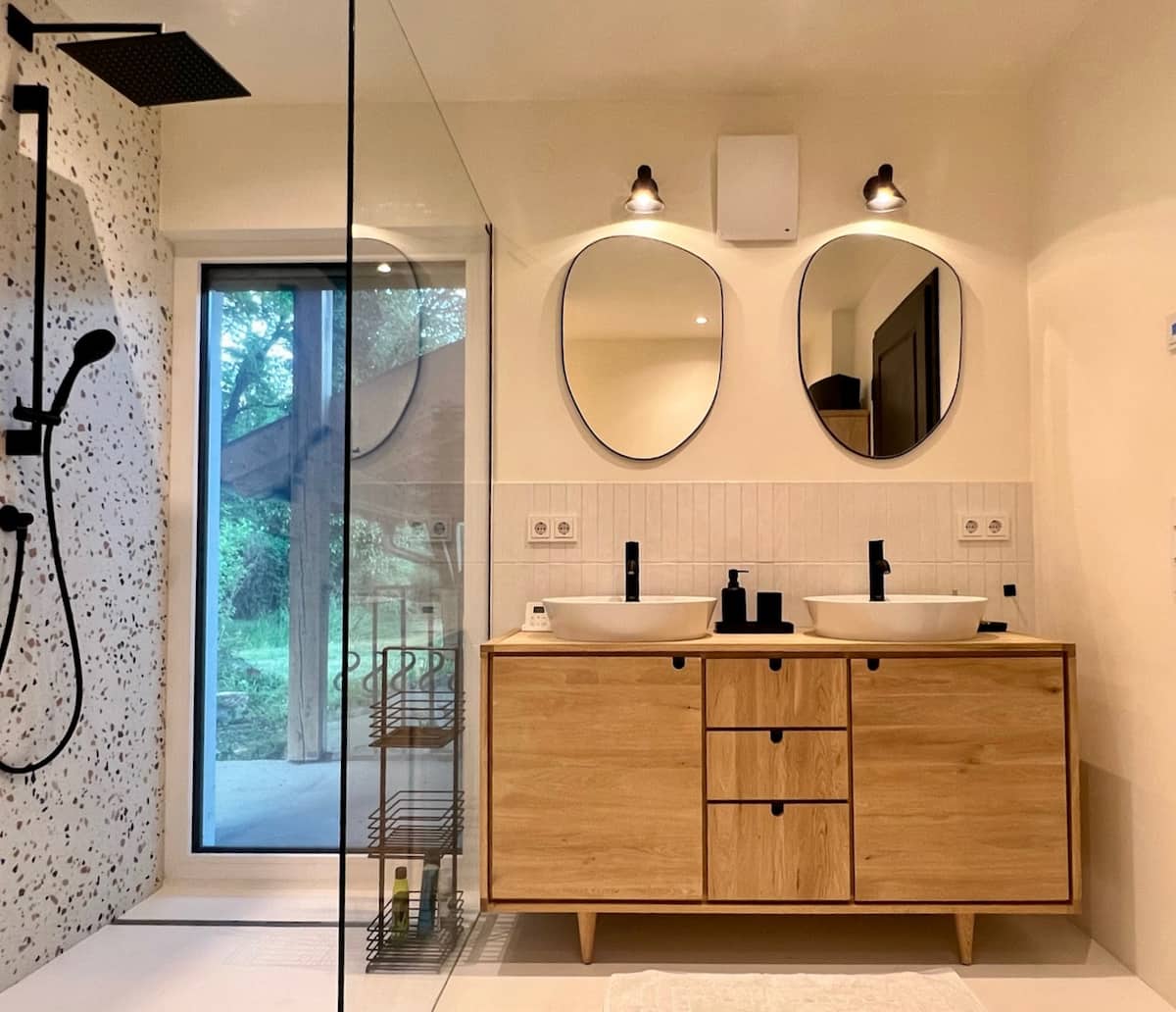 Badezimmer mit Holzwaschtisch und runden Spiegeln