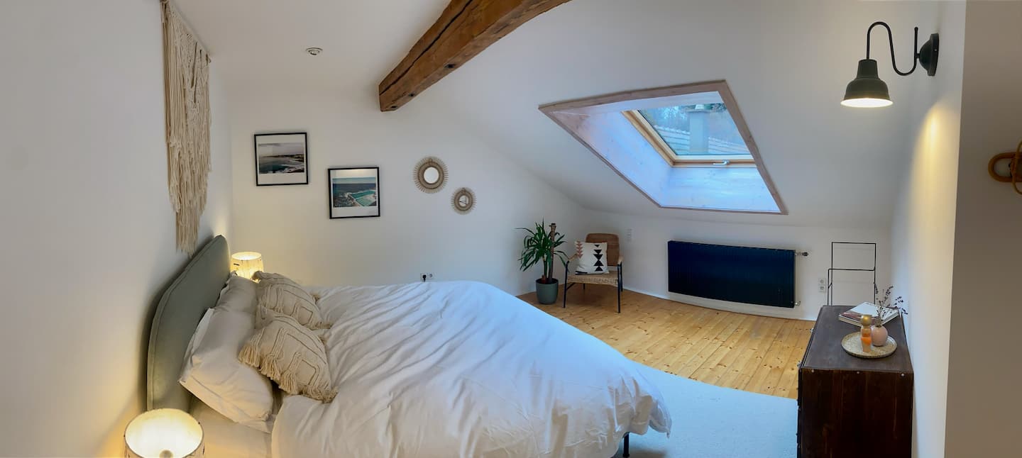 Schlafzimmer unter dem Dach mit sichtbaren Holzbalken