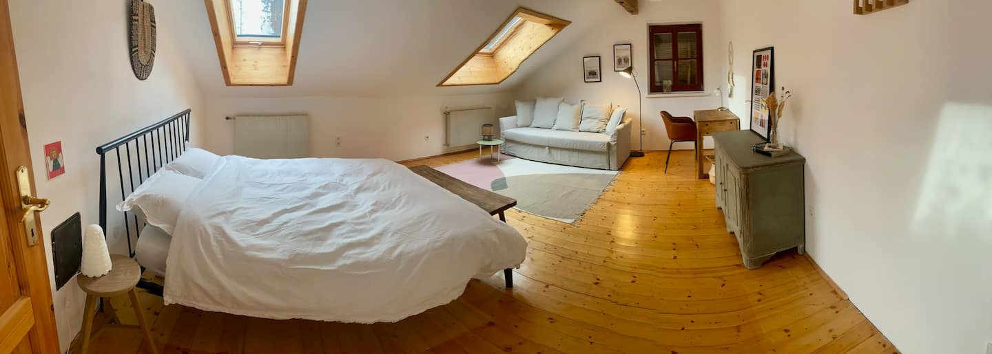 Großes Schlafzimmer mit Doppelbett und Sofa